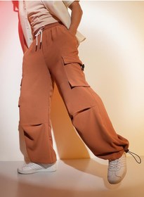 تصویر شلوار پاراچوتی کمرنگ قهوه‌ای مردانه با جیب‌های بزرگ برند campus sutra Men's Sienna Brown Solid Cargo Parachute Trousers