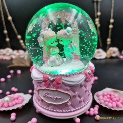 تصویر گوی شیشه ای بزرگ موزیکال پمپی برفی با شش طیف نوری طرح دختر و پسر I Love You صورتی 