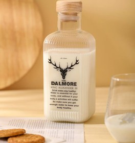 تصویر بطری شیشه ای چهار گوش در چوب 