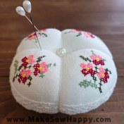 تصویر جا سوزنی پارچه‌ای طرح شماره‌دوزی رنگ سفید با گل‌های صورتی و زرشکی 