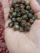 تصویر مهره سنگ سرپانتین سبز مغز پسته ای طرح اوناکیت سایز ۱۰تراش استار سوراخ دار 