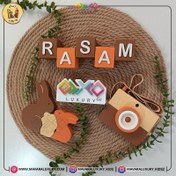 تصویر ست اکسسوری چوبی اتاق کودک همراه با استند مکعب اسم و پازل خانواده خرگوش با رنگ های نارنجی و گرم MKS133 