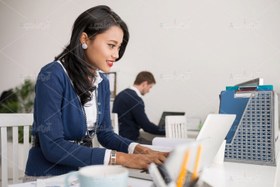 تصویر عکس با کیفیت زن با لباس آبی در حال تایپ 