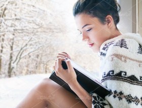 تصویر عکس با کیفیت دختر لب پنجره نشسته در فضای برفی 