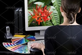 تصویر عکس با کیفیت زن پشت سیستم و نوتالیته روی میز 