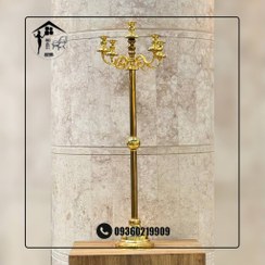 تصویر شمعدان کنار سالنی فلزی بلند 