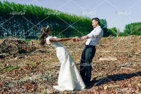 تصویر عکس با کیفیت عروس و داماد دست در دست هم با لبخند 