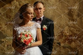 تصویر عکس با کیفیت عروس و داماد با دسته گل قرمز 