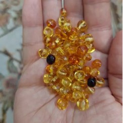 تصویر مهره سنگ کهربای نامنظم سوراخ دار سنگ اصل درجه یک طبیعی معدنی راف تراش نخورده دفرمه 