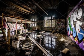 تصویر عکس با کیفیت اتاق مخروبه با نقاشی گرافیتی بر روی دیوارهایش 